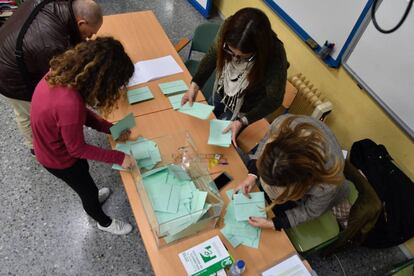 Varias personas recogen papeletas en un colegio electoral de El Ejido (Almería), este domingo.