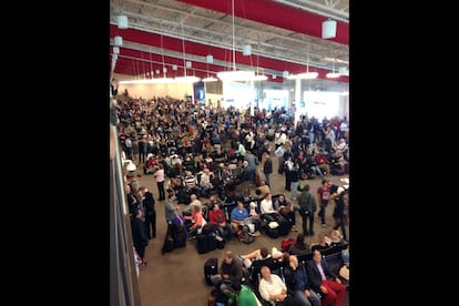 Un gran número de pasajeros espera en el aeropuerrto después de que fuera parcialmente cerrrado.