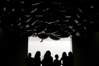 Varios periodistas observan la obra de arte 'Speech Bubbles' del artista francés Phillipe Parreno, durante un pase de prensa de la exposición 'Un espacio de tiempo coloreado'; una de las más grandes del artista y su primera muestra en Portugal, en el Museo Serralves, en Oporto.