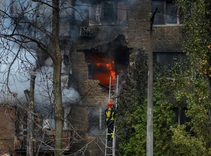 Un bombero intenta apagar este martes un incendio en un edificio de Kiev provocado por el impacto de un misil ruso.