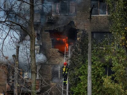 Un bombero intenta apagar este martes un incendio en un edificio de Kiev provocado por el impacto de un misil ruso.
