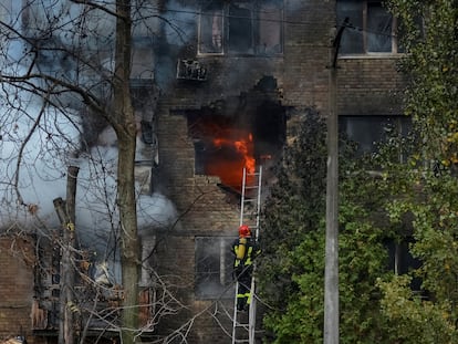 Bomberos intentan apagar este martes un incendio en un edificio de Kiev provocado por el impacto de un misil.