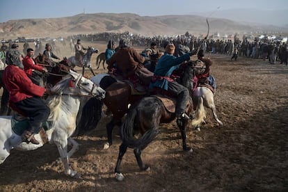 Varios jinetes compiten durante el buzkashi, un deporte de Asia Central en el que los jugadores montados a caballo intentan colocar un cadáver de animal decapitado en una portería, en Qara Shabagh, en las afueras de Aybak, en la provincia de Samangan (Afganistán).