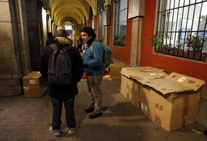 Un voluntario con un sin techo en la Plaza Mayor.