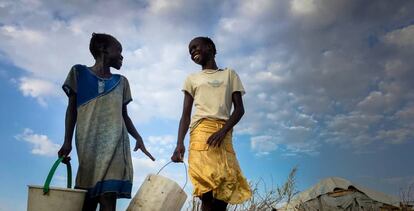 Dos chicas cargan cubos para agua en la zona de Alto Nilo de Sudán del Sur.