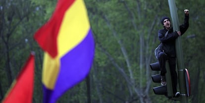 Un joven subido a un semáforo durante la protesta en la plaza de Neptuno.