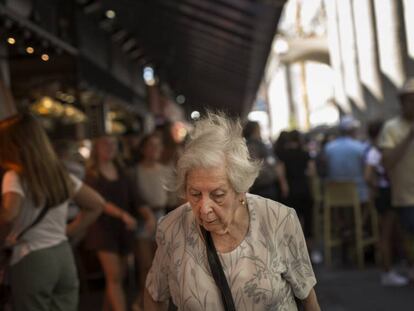 Una anciana passeja pel Mercat de la Boquería de Barcelona