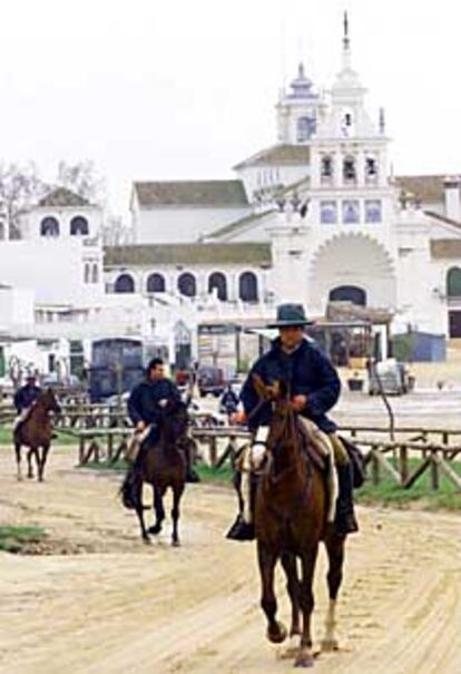 Tres romeros, ayer, en la aldea de El Rocío con sus caballos.