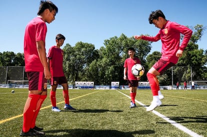 He Xiaoke, el goleador del sub-15 chino, toca el balón ante la mirada de sus compañeros en el centro de entrenamiento de LaLiga en Algete.