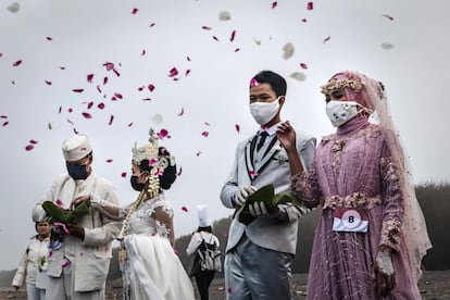 Dos parejas recién casadas lanzan flores al cielo en Yogyakarta (Indonesia).