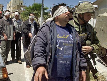 Miembros del ejército israelí conduce a uno de los palestinos detenidos durante la incursión en Hebrón.