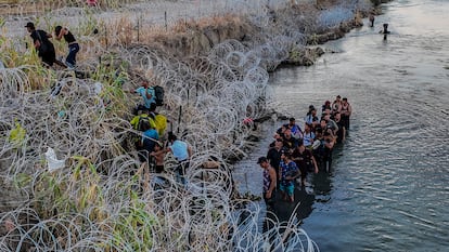 Migrants cross the barbed wire to reach Eagle Pass, Texas, in September 2023.