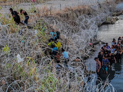 Migrants cross the barbed wire to reach Eagle Pass, Texas, in September 2023.