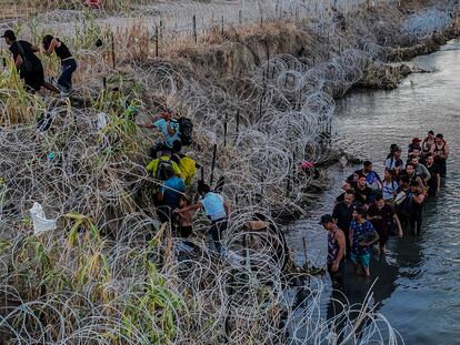 Migrantes cruzan el alambre de púas para llegar a Eagle Pass (Texas), en septiembre de 2023.