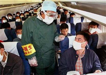 Un médico controla al pasaje de un avión de la compañía china Southern Airlines.