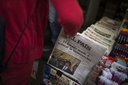 Una mujer coge un ejemplar del diario EL PAÍS de un quiosco de Barcelona.