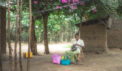 Speciose Mapendo teje cestos frente a su casa de Kiwanya (R.D. Congo).