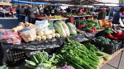 Un puesto de frutas y verduras en un mercdillo.