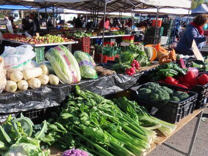 Un puesto de frutas y verduras en un mercdillo.