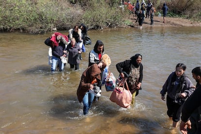 Un grupo de sirios alauitas cruzan el río Nahr El Kabir, el pasado martes en Akkar, Líbano, huyendo de la violencia.