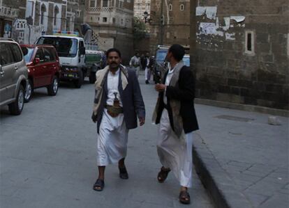 Dos hombres caminan por las calles de Saná, uno de ellos con la típica 'yanbia'.