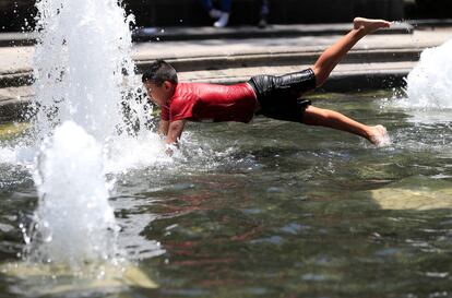 Un niño se refresca en una fuente en la Alameda Central la Ciudad de México.