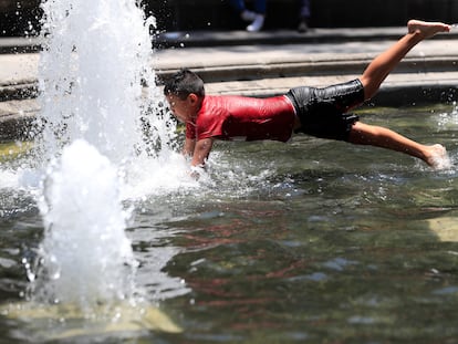 Un niño se refresca en una fuente en la Alameda Central la Ciudad de México.