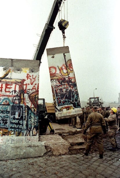 Una losa del muro de Berlín es levantada por una grúa de la Alemania del Este en la plaza de Postdamer para abrir el camino en otro puesto fronterizo, el 12 de noviembre.