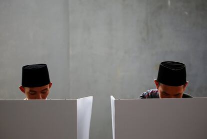 Dos votantes ejercen su voto durante las elecciones en Bogor, Java Occidental.