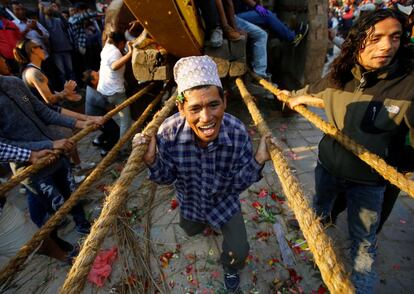Un devoto se aferra a las cuerdas atadas al carro del Dios Bhairab durante el Festival Biska, en Nepal.
