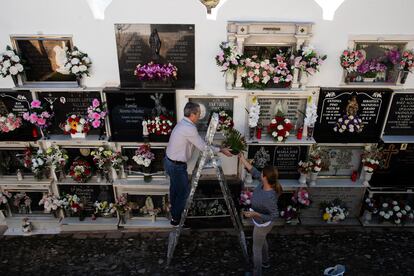 Unas personas colocan flores en el cementerio de Casabermeja (Málaga), este miércoles. 
