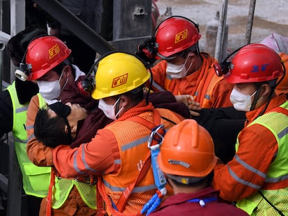 Trabajadores de los equipos de rescate ayudan a salir a uno de los mineros atrapados