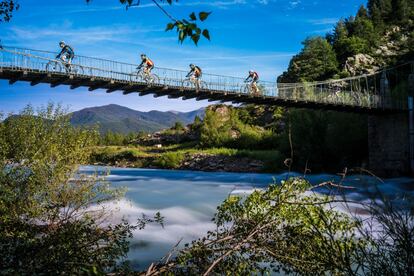 Los ciclistas cruzan un puente durante el recorrido de la carrera.