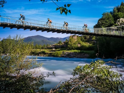 Los ciclistas cruzan un puente durante el recorrido de la carrera.