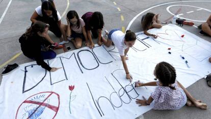 Niñas decoran una pancarta con el lema 'Democracia, Independencia' en el colegio Torrent D'en Melis de Barcelona.