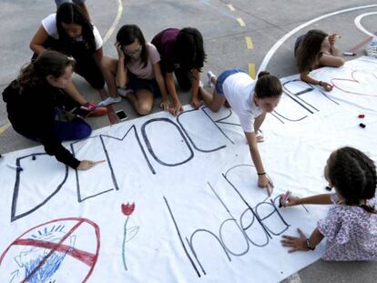 Niñas decoran una pancarta con el lema 'Democracia, Independencia' en el colegio Torrent D'en Melis de Barcelona.
