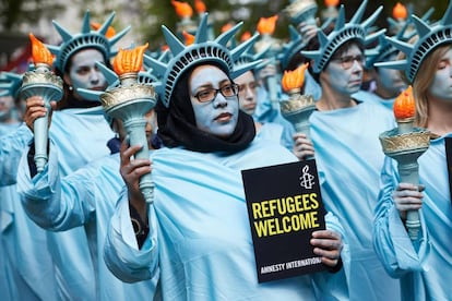 Activistas de Amnist&iacute;a Internacional disfrazados de Estatua de la Libertad en una protesta contra Trump.