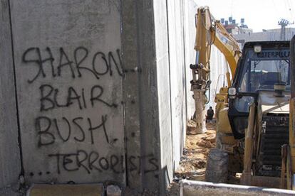 Una pintada en la que puede leerse "Sharon, Blair y Bush, terroristas", en el muro israelí.