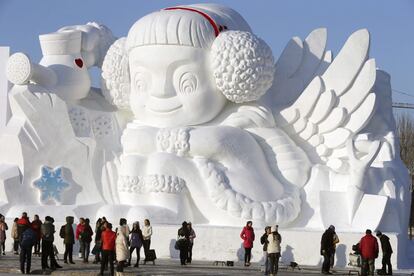 Un grupo de visitantes observan una escultura gigantesca de nieve y hielo en el Parque de la Isla del Sol, en la ciudad de Harbin, China. Harbin acoge el tradicional Festival de Nieve y Hielo que comenzó en 1963.