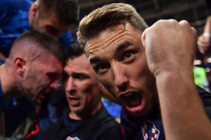 Josip Pivaric celebra el gol de su compañero Mandzukic (c) tras arrollar a un fotógrafo en la celebración del segundo gol del equipo en la semifinal frente a Inglaterra, el 11 de julio de 2018.