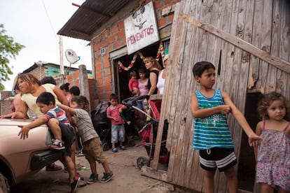 Niños juegan frente al comedor de beneficiencia Pekeñitos en el barrio Rafael Calzada de Buenos Aires.