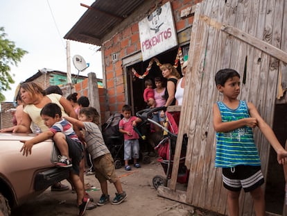 Niños juegan frente al comedor de beneficiencia Pekeñitos en el barrio Rafael Calzada de Buenos Aires.