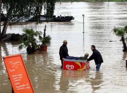 Unos vecinos rescatan cajas de cerveza en la orilla alemana del Rin, frente a la ciudad francesa de Estrasburgo.