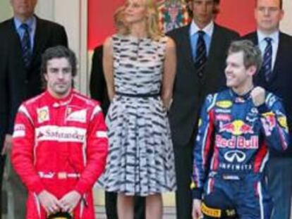 El piloto alemán de Fórmula 1 de la escudería Red Bull, Sebastian Vettel, celebra en el podio la victoria conseguida en el Gran Premio de Mónaco junto a Fernando Alonso, segundo, y a Jenson Button, tercero