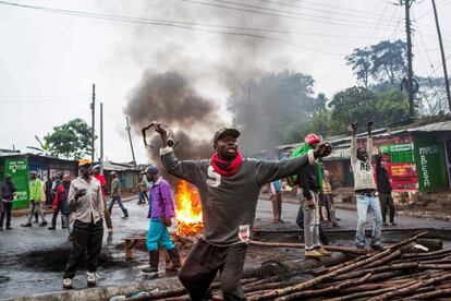 Un manifestante en Kibera (barrio chabolista de las afueras de Nairobi) se enfrenta a la Policía tras bloquear el acceso a un colegio electoral para que nadie pueda votar durante las elecciones presidenciales este jueves, 26 de octubre de 2017. Este barrio marginal es el bastión del líder opositor de la Súper Alianza Nacional (NASA, siglas en inglés), Raila Odinga, que este miércoles ha pedido a sus seguidores que se quedaran en sus casas y no votaran. Algunos de ellos han levantado barricadas para evitar que lleguen los materiales de votación a los colegios electorales.