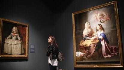 Una mujer ante 'La infanta Margarita de blanco', de Velázquez, en Sevilla. A su derecha, 'Santa Ana enseñando a leer a la Virgen', de Murillo