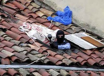 Un agente de la Policía Foral, en el tejado del edificio ocupado ayer en Pamplona.