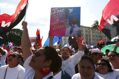 Un hombre levanta un cartel de Daniel Ortega. 