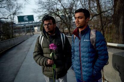 Michigan State international students Dheeraj Thota, left, and Chirag Bhansari, both freshman studying computer science, found a single rose on their walk to class as campus opens back up for the first day of classes on Monday, Feb. 20, 2023 at Michigan State University in East Lansing, Mich.