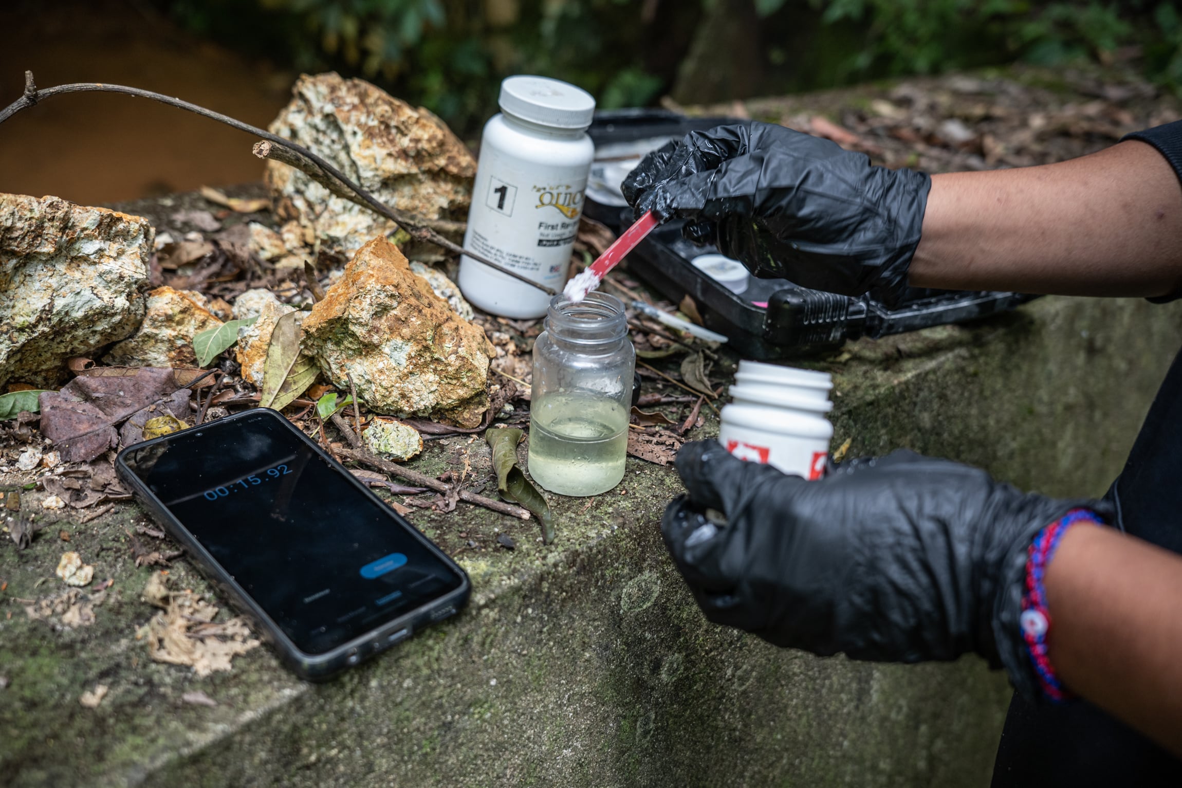 Diana Carillas Pacheco prepara el kit de monitoreo del arsénico cerca del drenaje de la mina artesanal, cerrada hace 90 años, en Morales, Mataquescuintla el 29 de octubre de 2024.